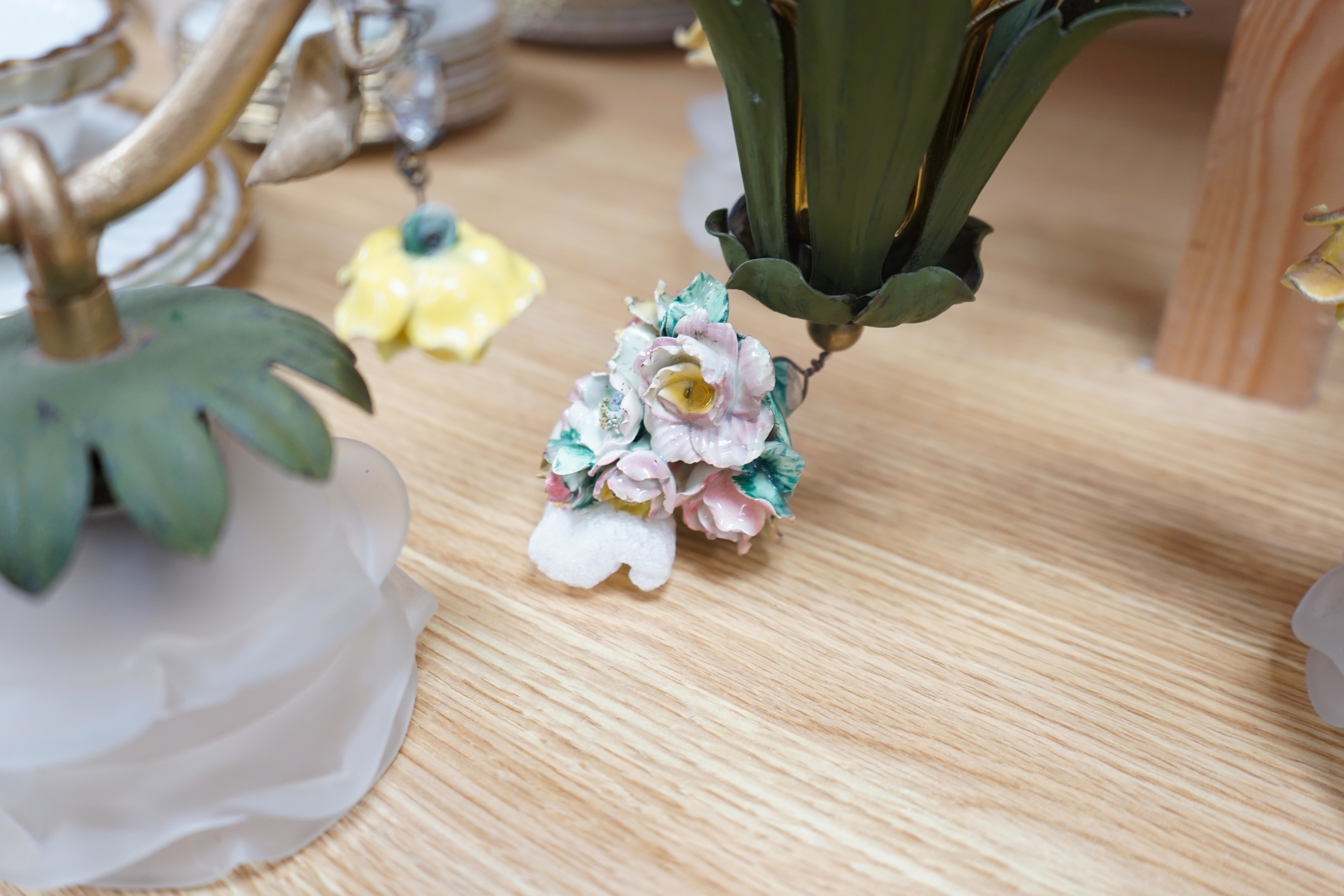 A French three arm coloured wrought iron ceiling light with frosted petal shades and porcelain flower decoration, circa 1930’s, 57cm high, 36cm across. Condition - fair